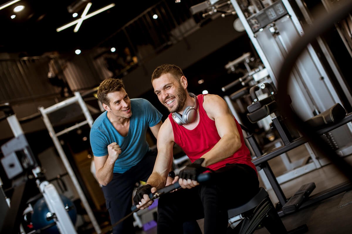 young-man-with-trainer-doing-exercise-in-the-gym-TETHN6F.jpg